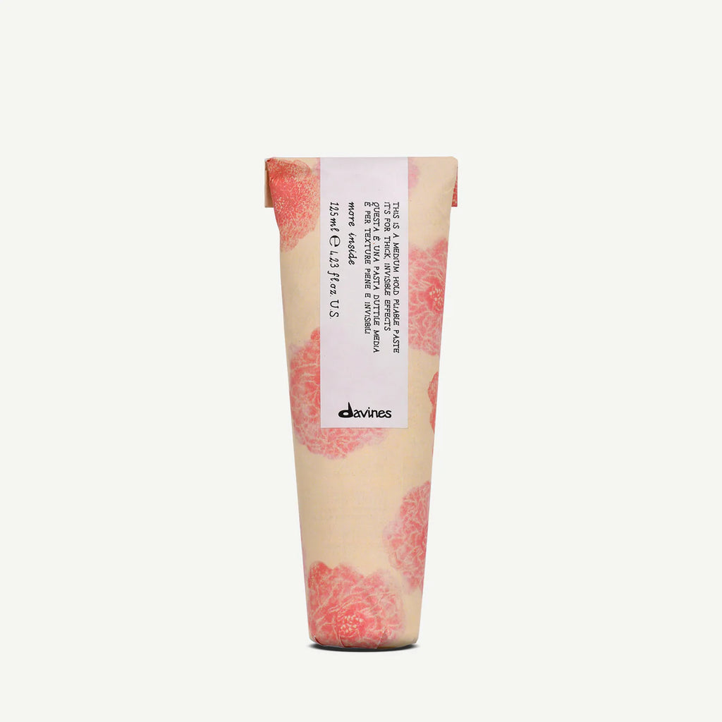 Tub of Davines hair product with pink and white design on a white background